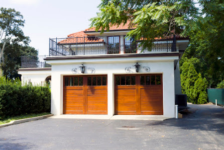 Home exterior with two wooden garage doors and a paved driveway